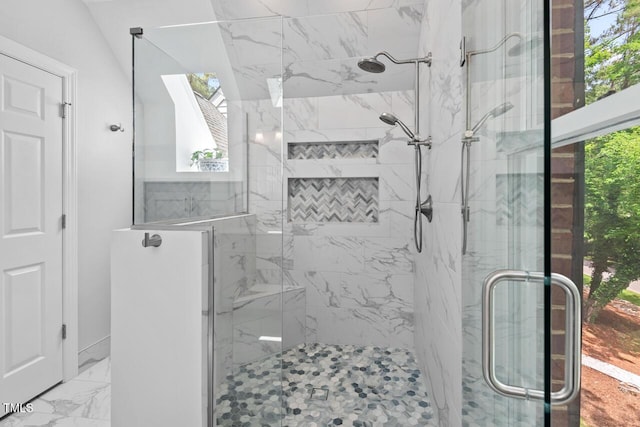 bathroom featuring healthy amount of natural light, a marble finish shower, and marble finish flooring