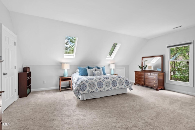 carpeted bedroom featuring a skylight, vaulted ceiling, and baseboards