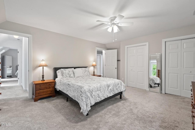bedroom featuring carpet floors, multiple closets, and ceiling fan
