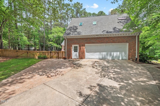 view of home's exterior featuring brick siding, a shingled roof, concrete driveway, and fence