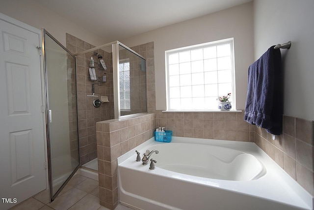 full bathroom featuring a stall shower, a bath, and tile patterned floors