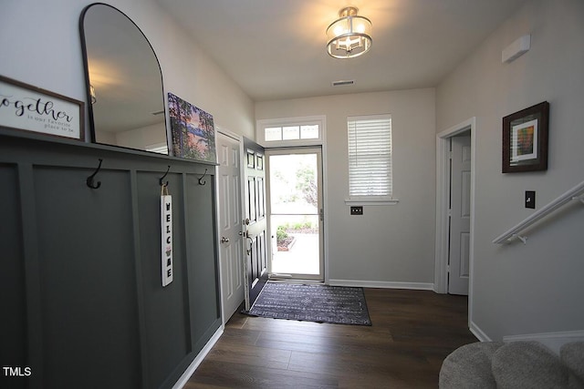 foyer with dark wood-type flooring and baseboards