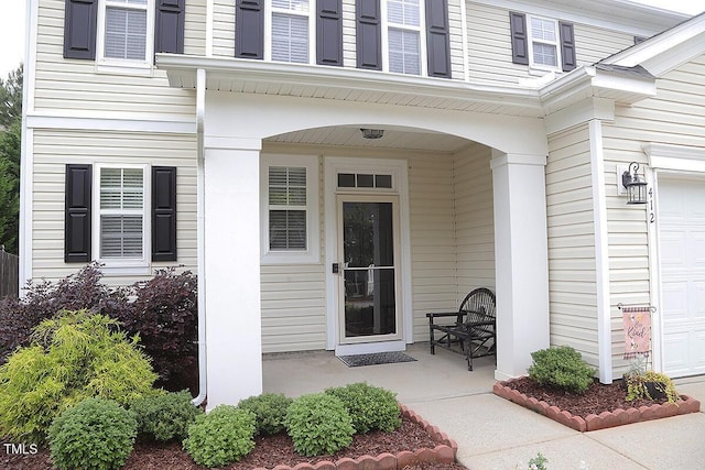 doorway to property featuring covered porch and an attached garage