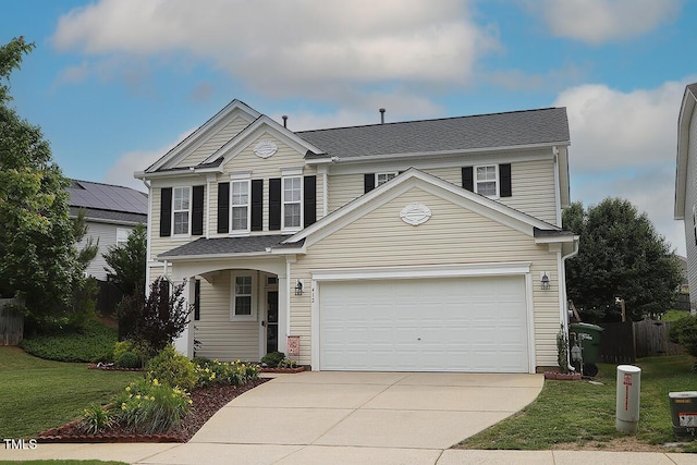 traditional-style home with concrete driveway and a front yard