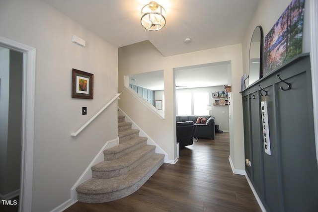 entrance foyer with stairs, dark wood finished floors, and baseboards