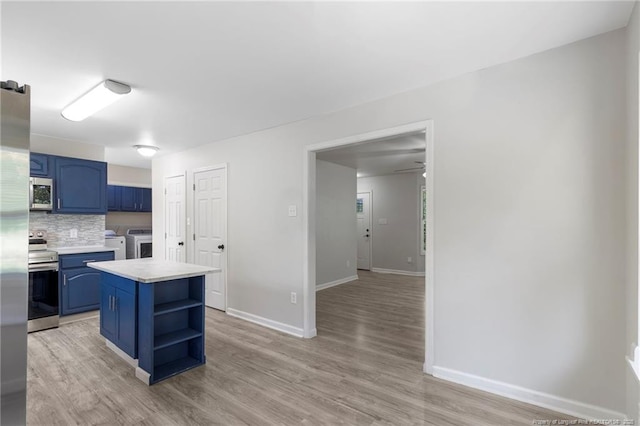 70 Oregon Ln, Spring Lake, NC 28390 - kitchen featuring blue cabinetry, stainless steel appliances, washer and clothes dryer, open shelves, and light countertops