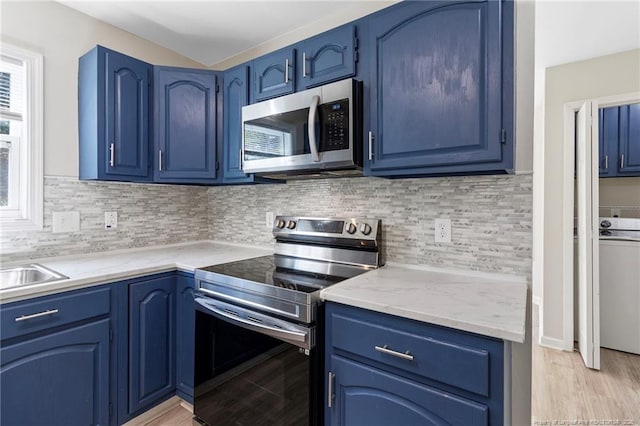 70 Oregon Ln, Spring Lake, NC 28390 - kitchen with appliances with stainless steel finishes, blue cabinetry, light wood-style floors, and washer / clothes dryer