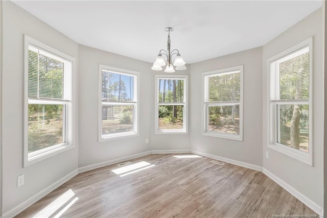 70 Oregon Ln, Spring Lake, NC 28390 - unfurnished dining area featuring a chandelier, light wood-style flooring, and baseboards