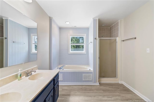 70 Oregon Ln, Spring Lake, NC 28390 - bathroom featuring double vanity, a garden tub, a shower stall, wood finished floors, and baseboards