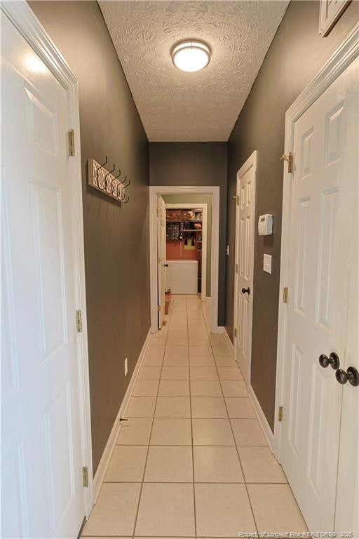 3603 Talus Rd, Fayetteville, NC 28306 - hall with light tile patterned floors, a textured ceiling, and baseboards