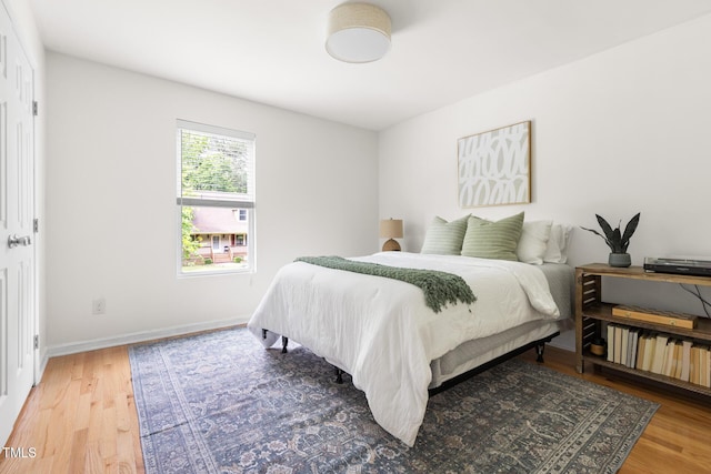 bedroom with light wood-style flooring and baseboards