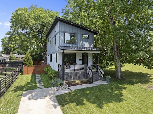 view of front of house with board and batten siding, a porch, stairs, a standing seam roof, and metal roof