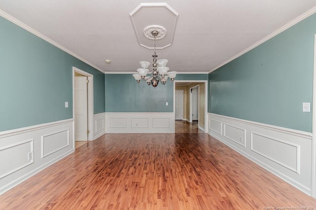 225 Lakeview Dr, Sanford, NC 27332 - empty room with a chandelier, ornamental molding, wood finished floors, a decorative wall, and a wainscoted wall