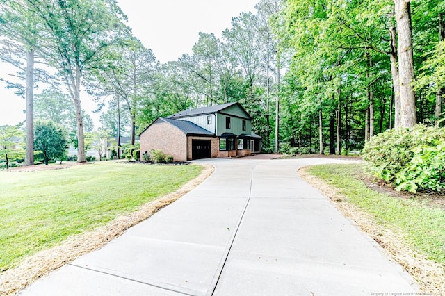 225 Lakeview Dr, Sanford, NC 27332 - view of front facade with driveway, brick siding, a garage, a front yard, and view of wooded area