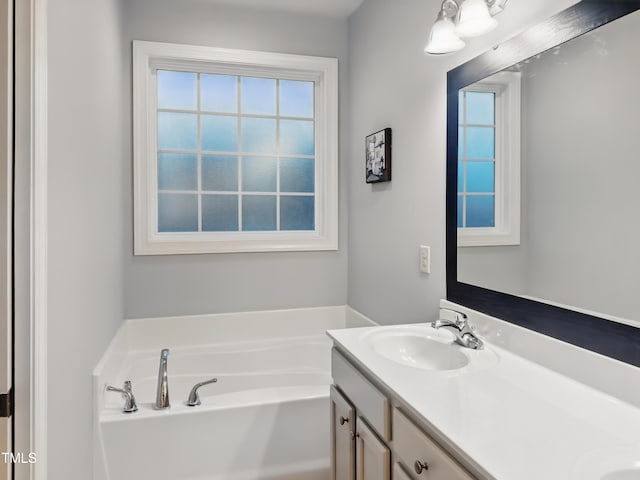 bathroom with plenty of natural light, double vanity, and a garden tub
