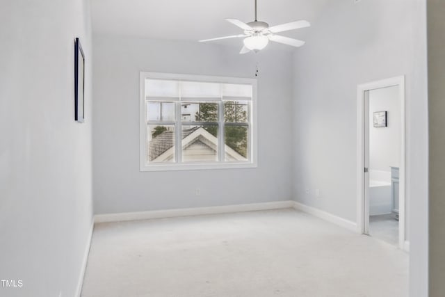 carpeted spare room with baseboards, ceiling fan, and vaulted ceiling