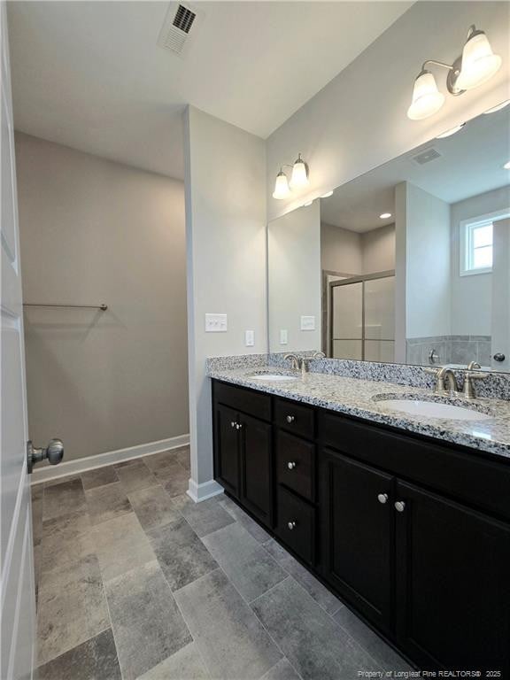 338 E David Parnell St, Parkton, NC 28371 - full bath featuring double vanity, a shower stall, and baseboards