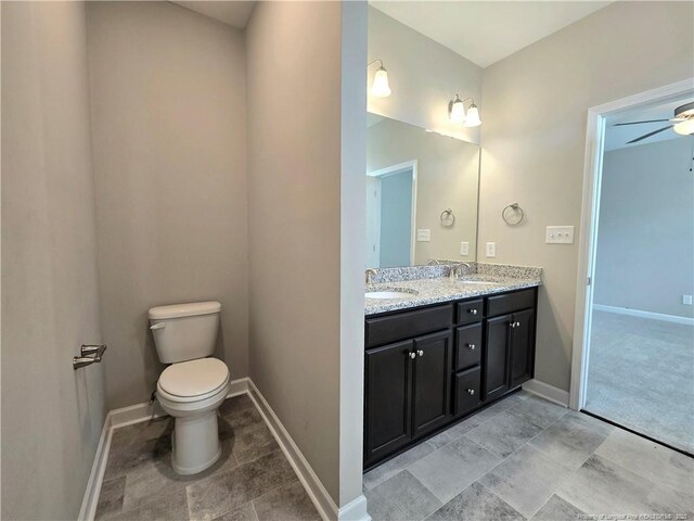 338 E David Parnell St, Parkton, NC 28371 - full bathroom featuring double vanity, baseboards, toilet, and a ceiling fan