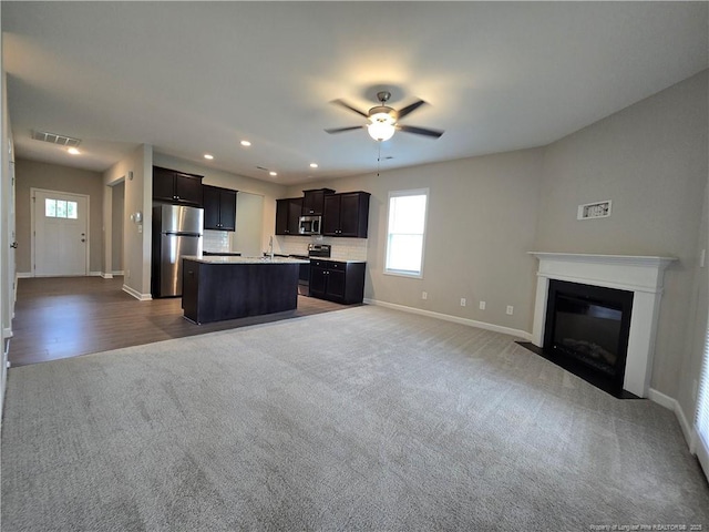 338 E David Parnell St, Parkton, NC 28371 - kitchen with appliances with stainless steel finishes, open floor plan, dark carpet, light countertops, and ceiling fan
