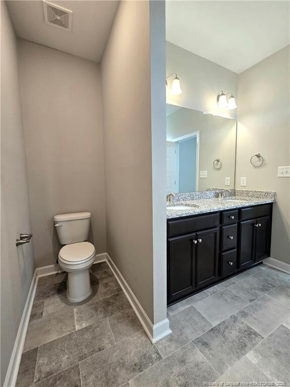 338 E David Parnell St, Parkton, NC 28371 - bathroom featuring double vanity and stone finish floors