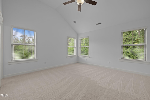 carpeted spare room featuring baseboards, ceiling fan, and high vaulted ceiling
