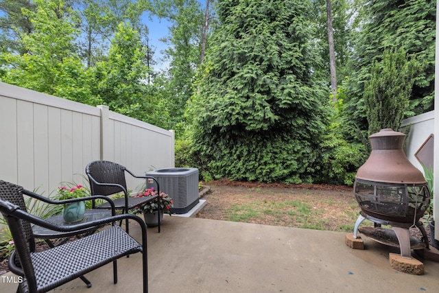 view of patio featuring central AC unit and fence