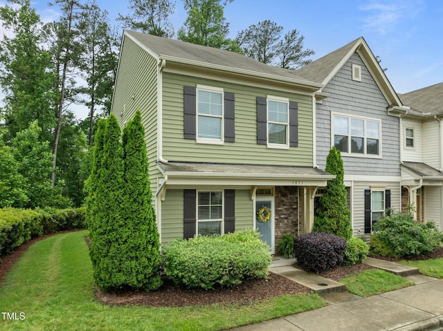 townhome / multi-family property with a front yard
