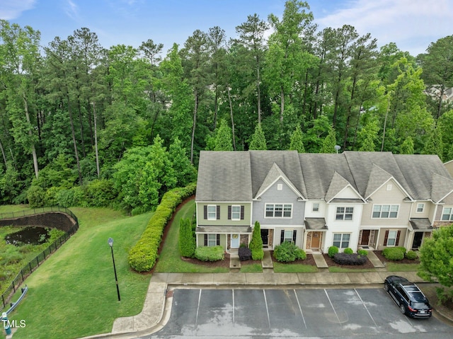 view of front of home featuring uncovered parking and a front yard