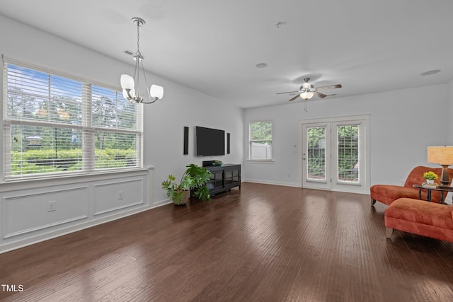 living area with wood finished floors, a chandelier, ceiling fan, and baseboards