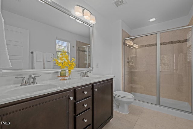 bathroom featuring tile patterned flooring, toilet, a stall shower, and double vanity
