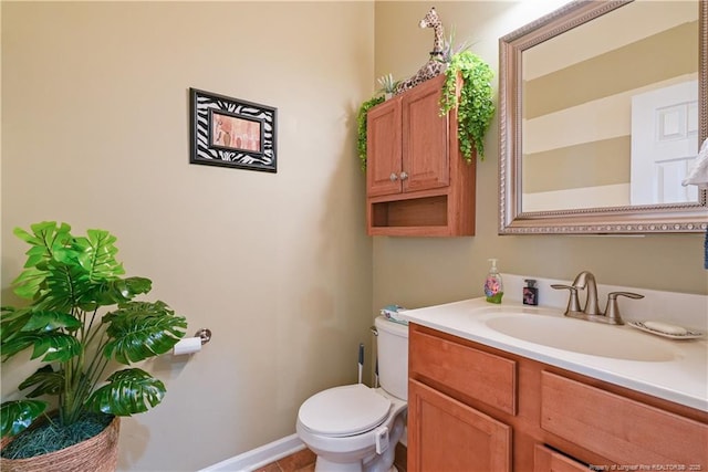 bathroom featuring toilet, vanity, and baseboards