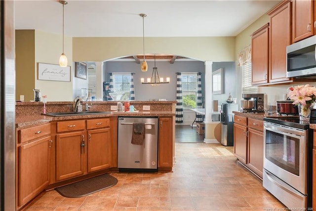kitchen with stainless steel appliances, a sink, healthy amount of natural light, and a peninsula