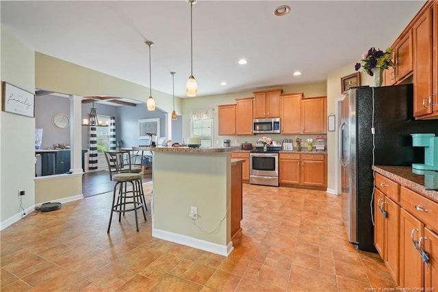 kitchen with stainless steel appliances, a kitchen breakfast bar, a center island, pendant lighting, and baseboards