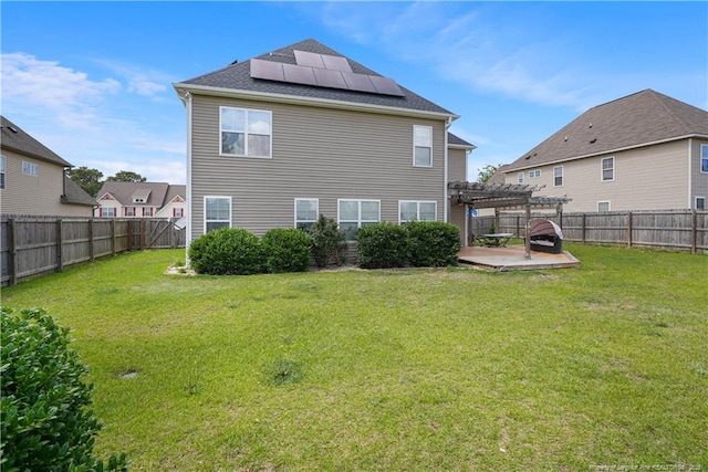 back of house featuring a pergola, solar panels, a patio area, and roof with shingles