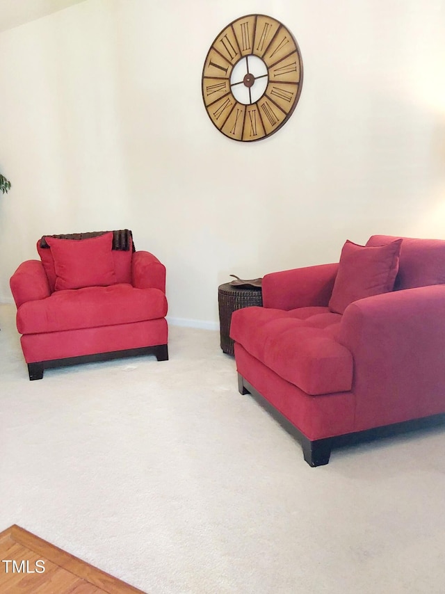 living area featuring carpet and baseboards