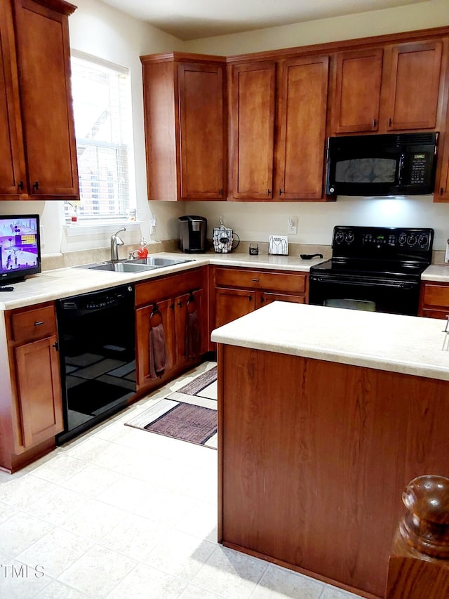 kitchen with black appliances, a sink, light countertops, and brown cabinets