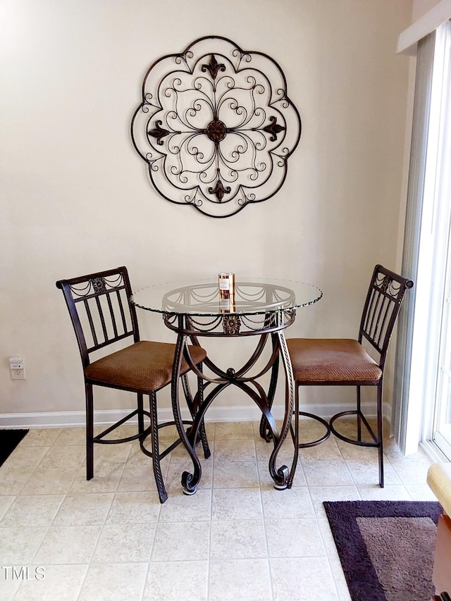 dining space with light tile patterned floors and baseboards