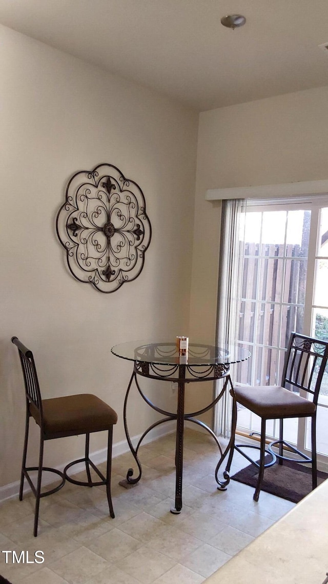 dining room featuring baseboards and light tile patterned flooring