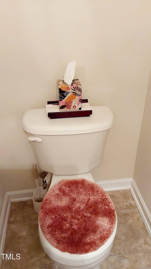 bathroom featuring toilet, tile patterned floors, and baseboards