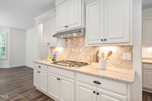 kitchen with under cabinet range hood, baseboards, dark wood-type flooring, stainless steel gas stovetop, and white cabinetry