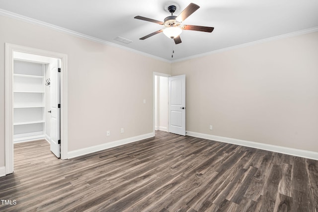 unfurnished room with dark wood finished floors, crown molding, baseboards, and ceiling fan
