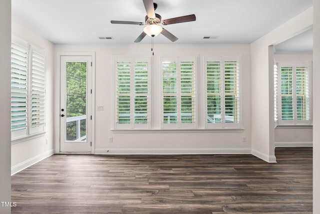 unfurnished room featuring ceiling fan, baseboards, and dark wood-type flooring