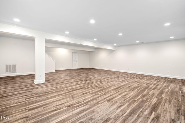 finished below grade area with recessed lighting, wood finished floors, baseboards, and crown molding