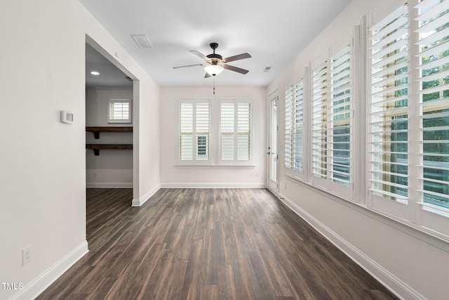 empty room featuring dark wood finished floors, ceiling fan, and baseboards