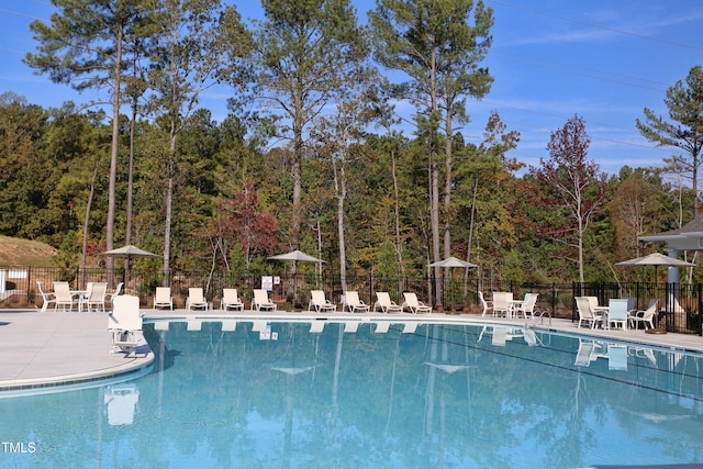 community pool featuring fence and a patio