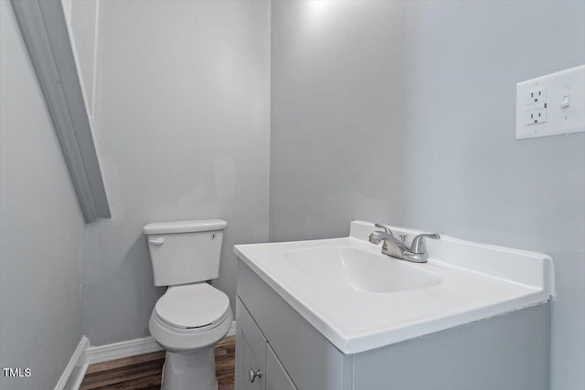 134 Nelson St, Durham, NC 27707 - half bath with vanity, toilet, wood finished floors, and baseboards