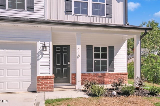 110 Hays St, Oxford, NC 27565 - entrance to property featuring brick siding, board and batten siding, a garage, and a porch