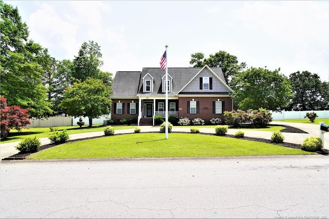 cape cod house with covered porch and brick siding