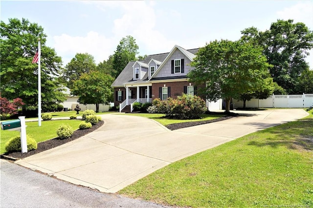 view of front of home featuring curved driveway, brick siding, and a porch