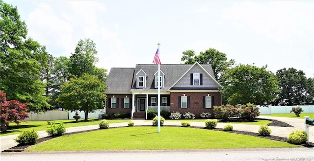 cape cod-style house with covered porch and brick siding